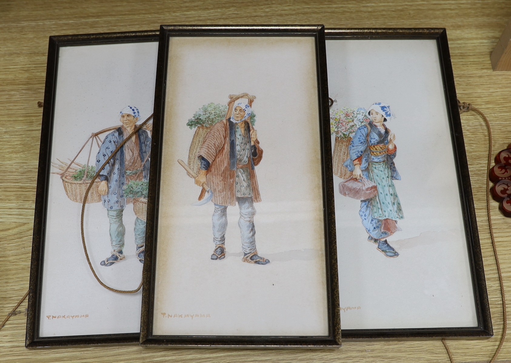 Takashi Nakayama (Japanese, 1893-1978), three watercolours, Studies of peasants carrying baskets of flowers and vegetables, signed, 33 x 16cm